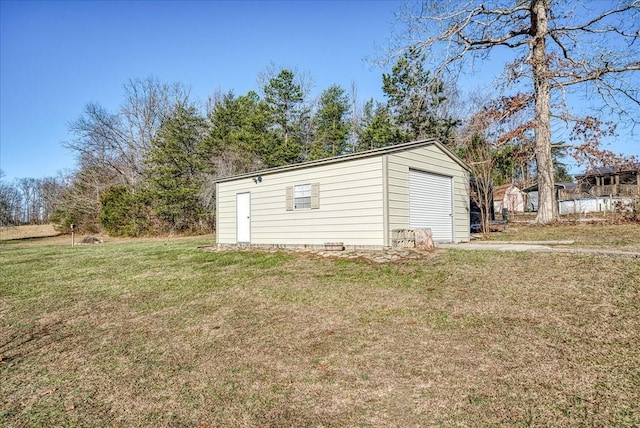 view of outdoor structure featuring a lawn and a garage