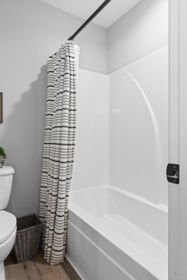 bathroom with wood-type flooring, toilet, and shower / bathtub combination with curtain