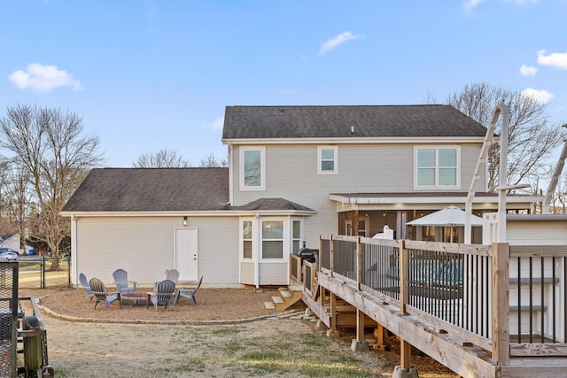 back of property featuring an outdoor fire pit and a deck