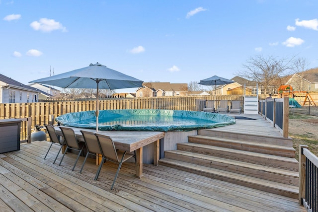 view of swimming pool with a deck and a playground