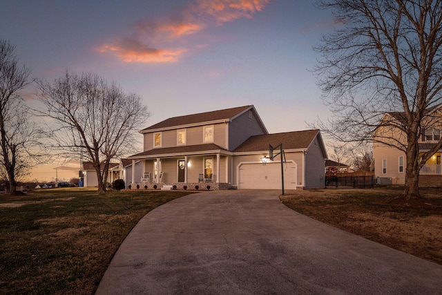 view of front of property with a garage, covered porch, and a lawn