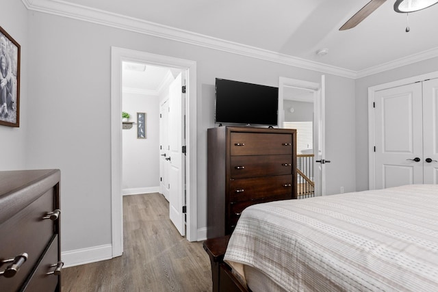 bedroom featuring light hardwood / wood-style floors, a closet, ceiling fan, and ornamental molding