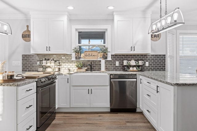 kitchen with decorative light fixtures, white cabinetry, sink, black electric range oven, and stainless steel dishwasher