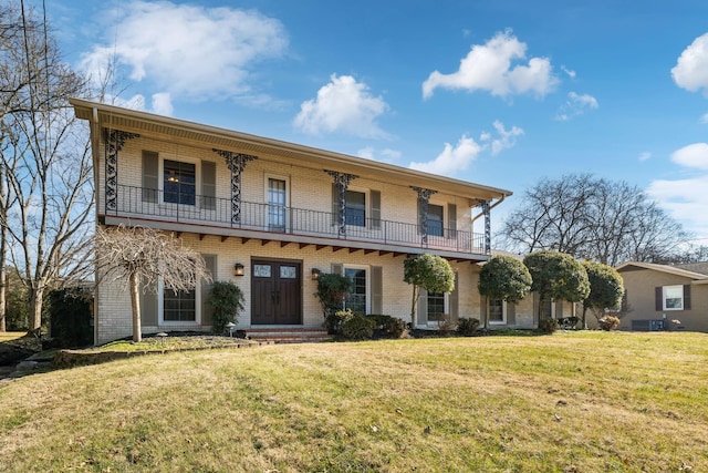 view of front of house featuring a balcony and a front yard