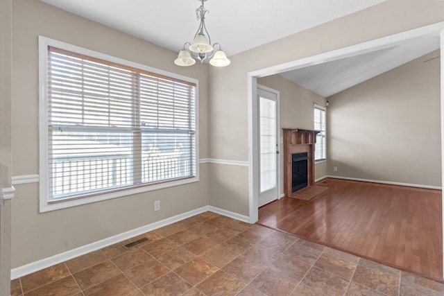 unfurnished living room featuring vaulted ceiling and a chandelier