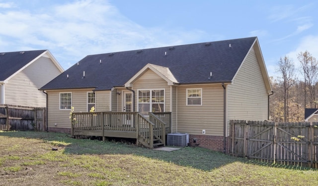 back of property with central AC unit, a lawn, and a deck