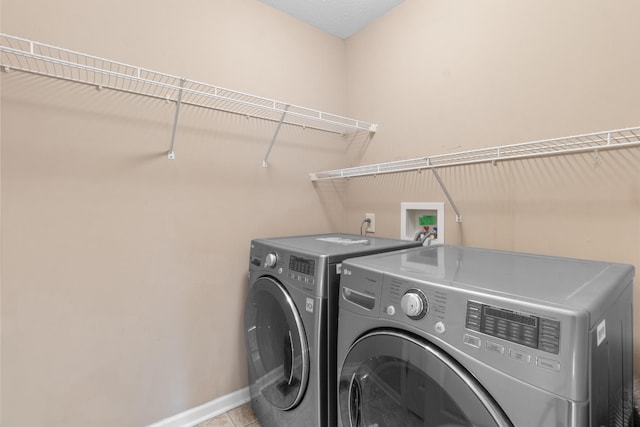 laundry area featuring tile patterned floors and washing machine and clothes dryer