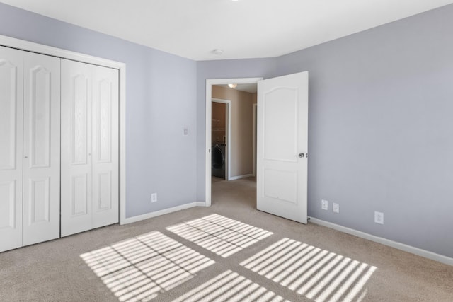 unfurnished bedroom featuring light colored carpet, a closet, and washer / clothes dryer