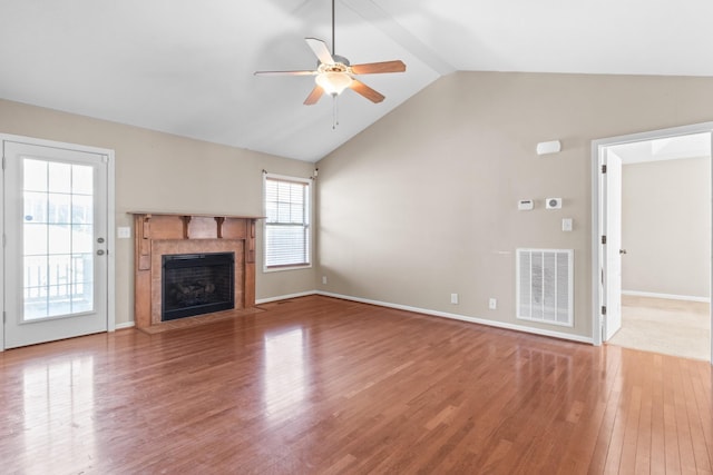 unfurnished living room with ceiling fan, hardwood / wood-style floors, a fireplace, and lofted ceiling