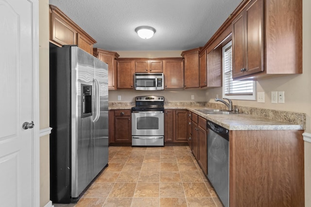 kitchen with sink, stainless steel appliances, and a textured ceiling