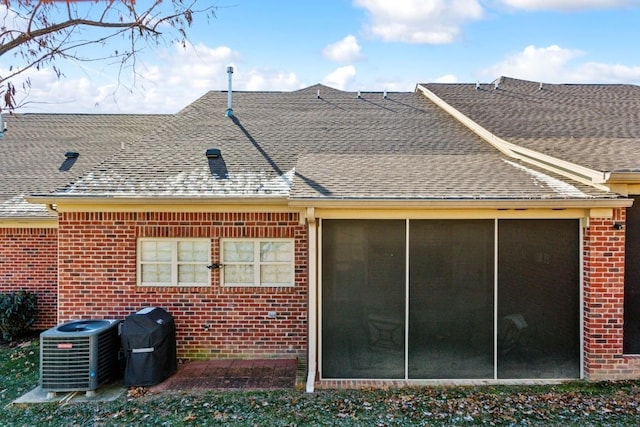 back of house featuring central air condition unit and a sunroom