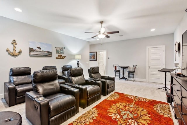 carpeted home theater room with ceiling fan