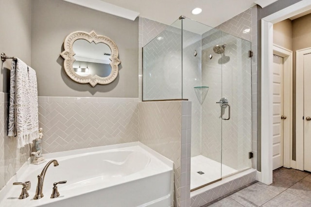 bathroom with separate shower and tub and tile patterned flooring