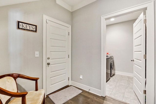 entryway with washer and clothes dryer and light hardwood / wood-style flooring