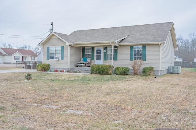 ranch-style house featuring covered porch, a front yard, and central AC