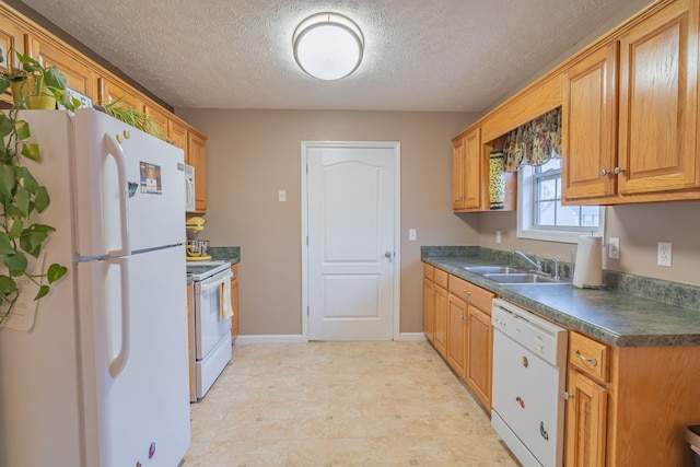 kitchen featuring sink, white appliances, and a textured ceiling