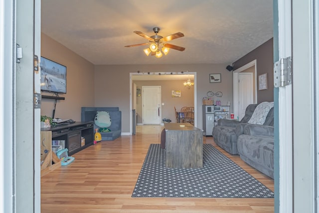 living room with hardwood / wood-style flooring, a textured ceiling, and ceiling fan