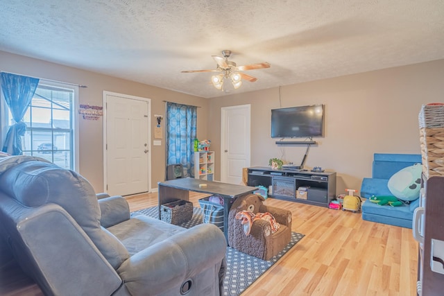 living room with ceiling fan, hardwood / wood-style floors, and a textured ceiling