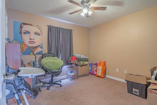 carpeted office featuring ceiling fan and a textured ceiling