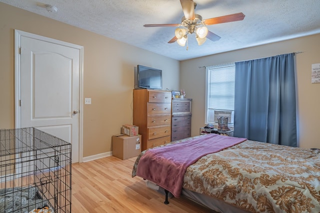 bedroom featuring ceiling fan, a textured ceiling, and light hardwood / wood-style flooring