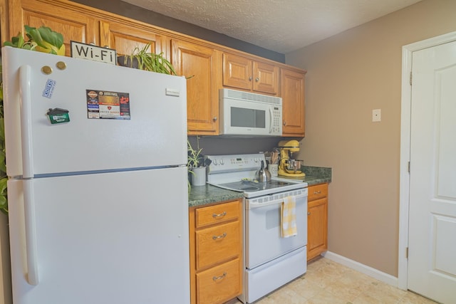 kitchen with white appliances and a textured ceiling