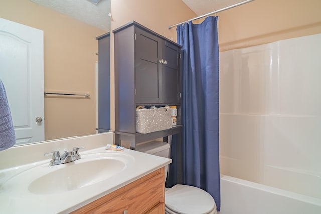 full bathroom featuring vanity, toilet, shower / bath combo with shower curtain, and a textured ceiling