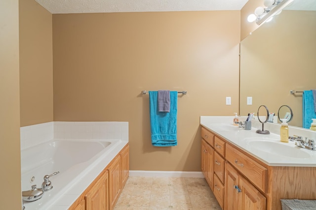 bathroom with a textured ceiling, tile patterned flooring, a bath, and vanity