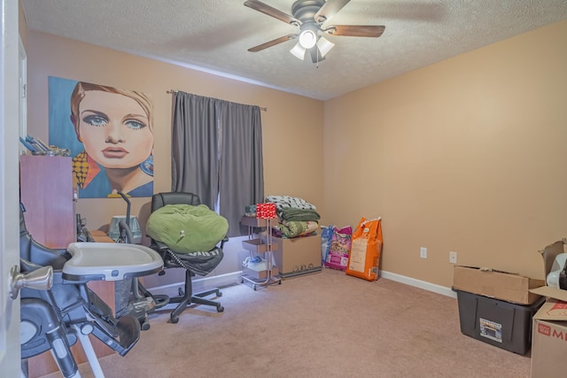 carpeted home office featuring ceiling fan and a textured ceiling