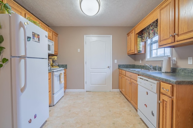 kitchen with sink, white appliances, and a textured ceiling