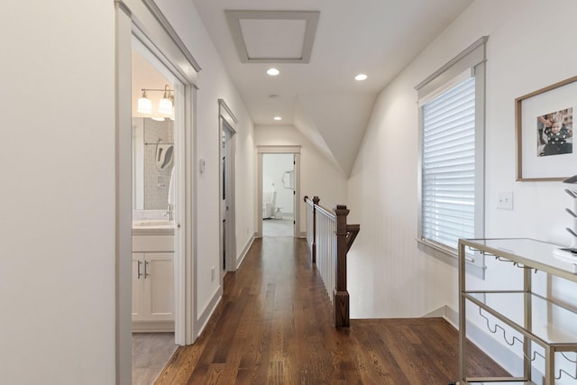 hall with sink, dark hardwood / wood-style flooring, and lofted ceiling