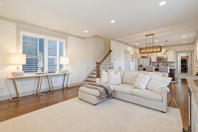 living room with dark wood-type flooring and ornamental molding