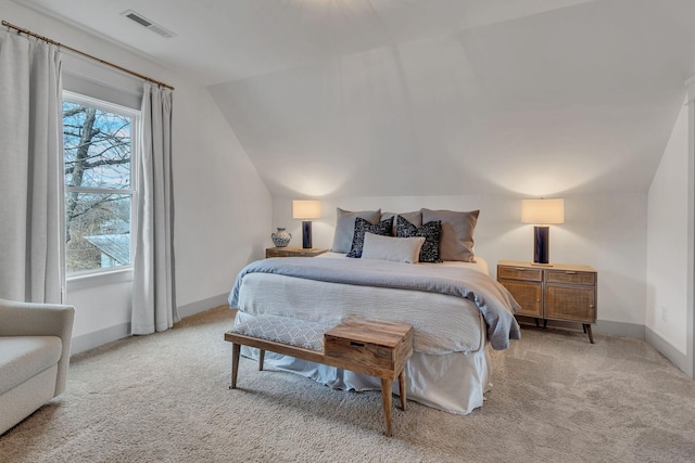 bedroom featuring light carpet and vaulted ceiling