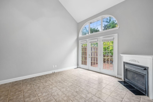 unfurnished living room featuring french doors, high vaulted ceiling, and light tile patterned floors