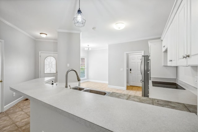 kitchen featuring black electric stovetop, white cabinetry, stainless steel refrigerator, sink, and decorative light fixtures