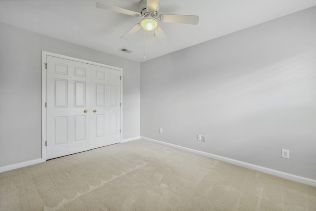 unfurnished bedroom featuring a closet, ceiling fan, and carpet flooring