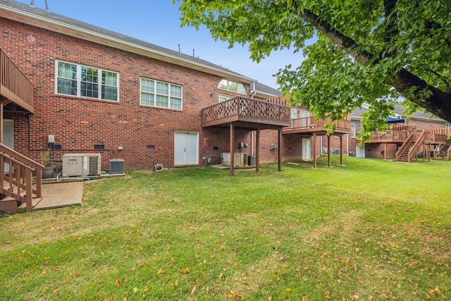 back of property featuring a wooden deck, a lawn, and central air condition unit