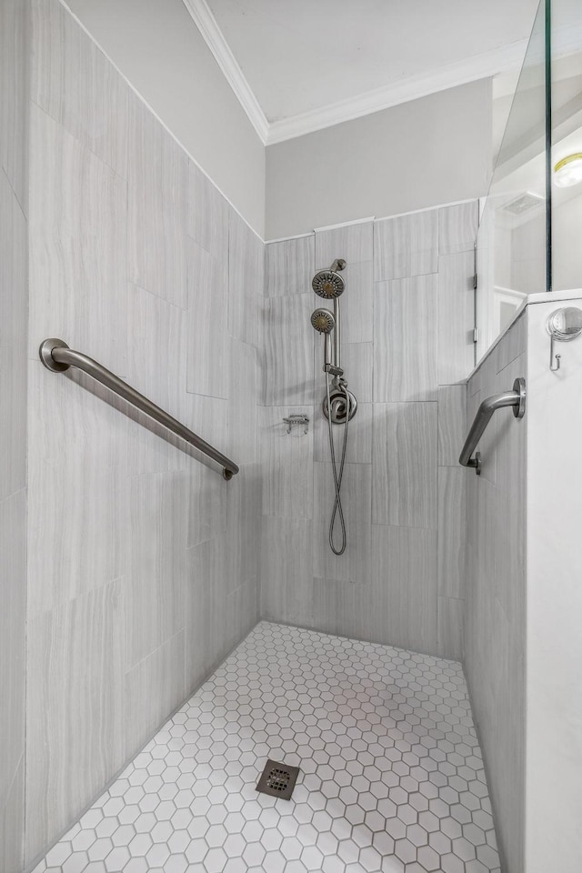 bathroom with crown molding and a tile shower