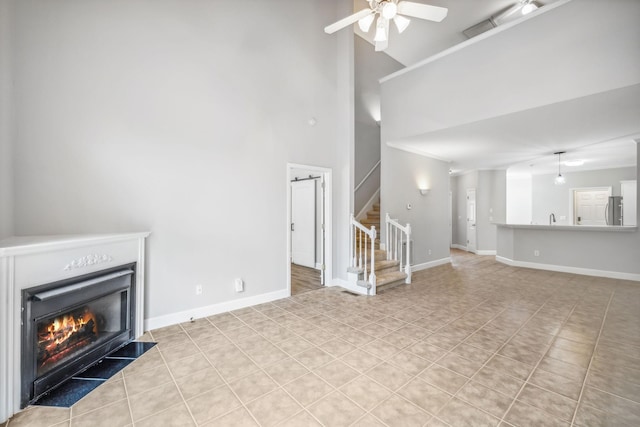 unfurnished living room featuring ceiling fan, high vaulted ceiling, and light tile patterned floors