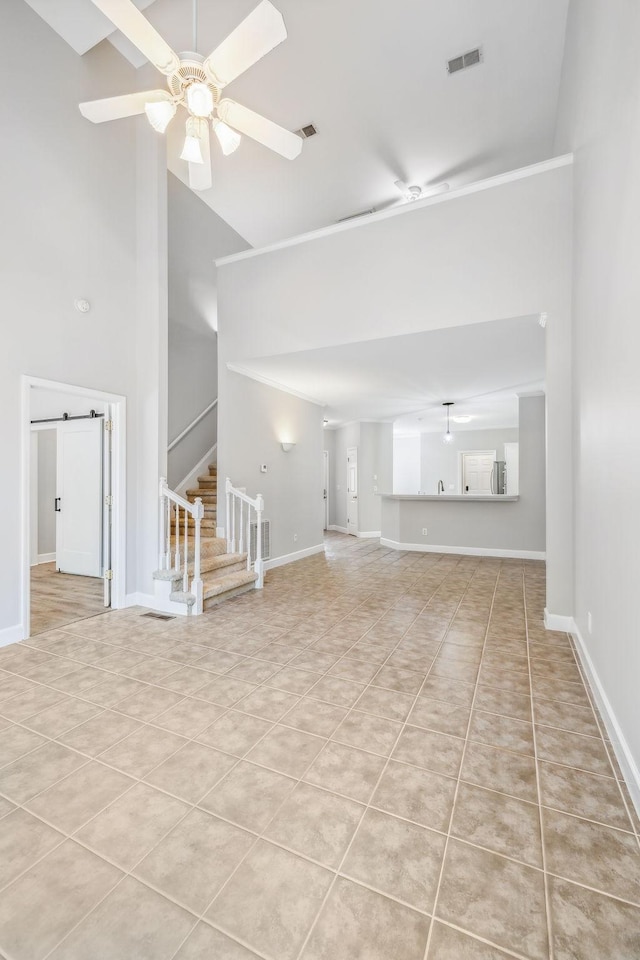 unfurnished living room with ceiling fan, light tile patterned floors, and high vaulted ceiling