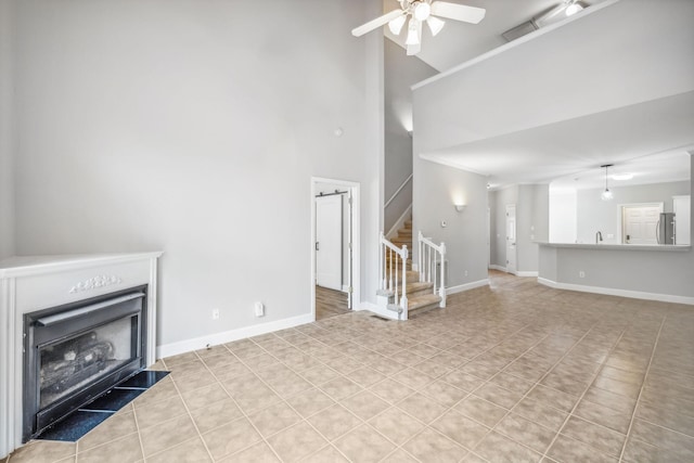 unfurnished living room with light tile patterned flooring, high vaulted ceiling, and ceiling fan