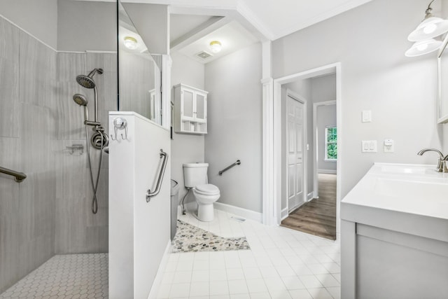 bathroom with tiled shower, vanity, toilet, and tile patterned flooring