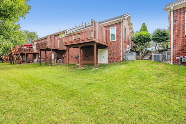 rear view of property with a wooden deck, a yard, and central air condition unit