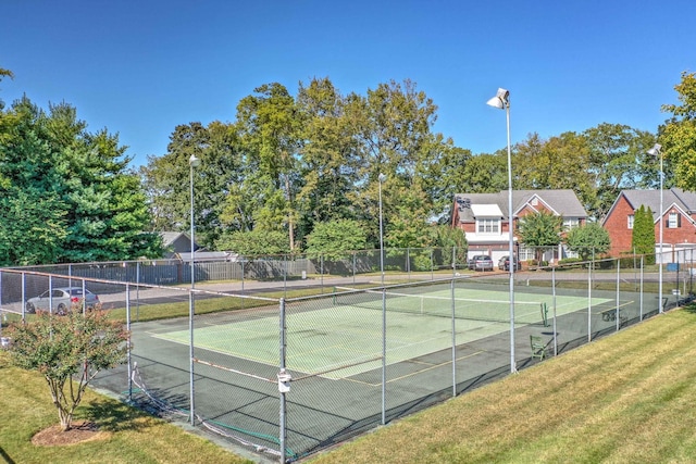 view of tennis court with a lawn