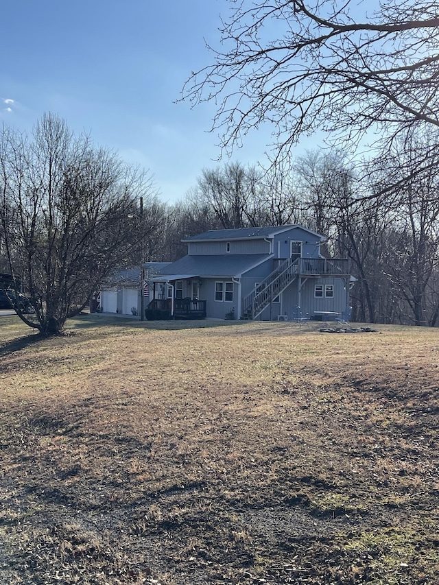 rear view of house featuring a lawn and a wooden deck