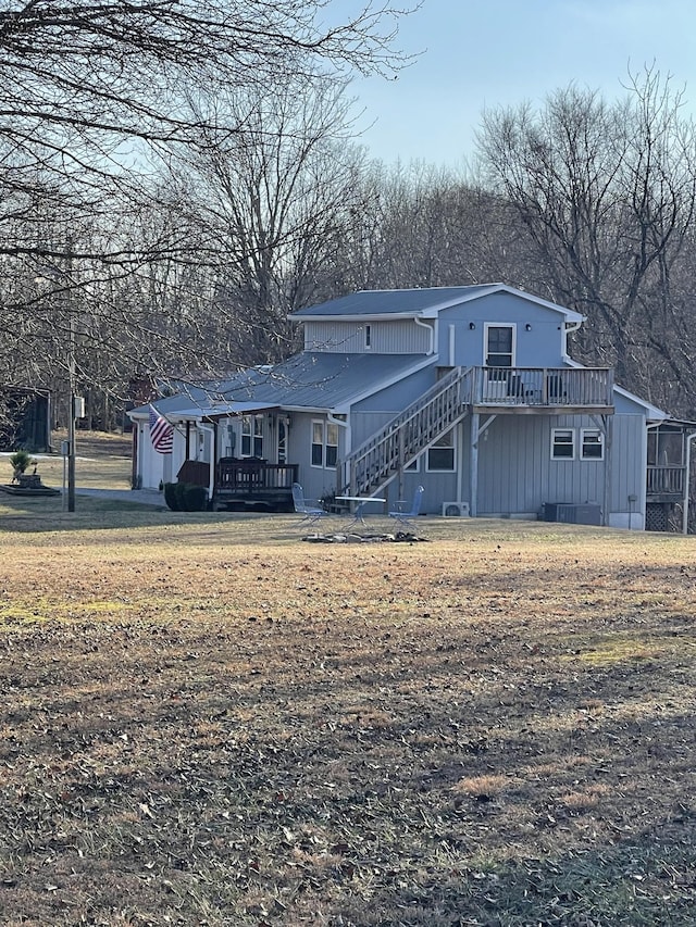 rear view of property featuring a yard and a deck