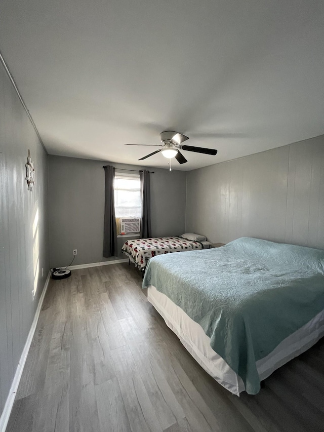 unfurnished bedroom with wood-type flooring, cooling unit, and ceiling fan