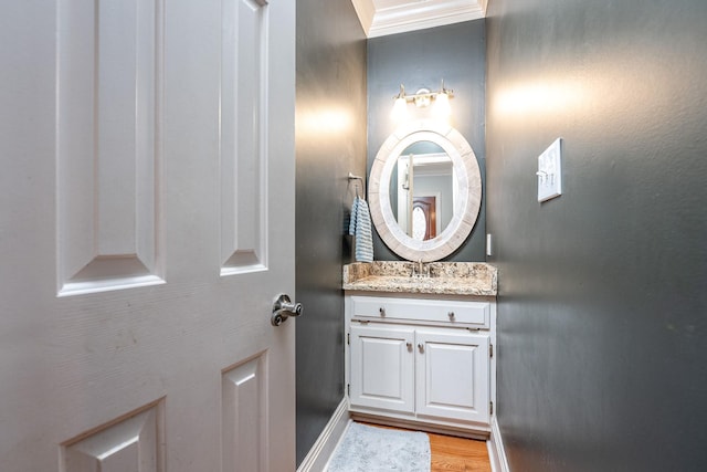 bathroom featuring hardwood / wood-style flooring, ornamental molding, and vanity