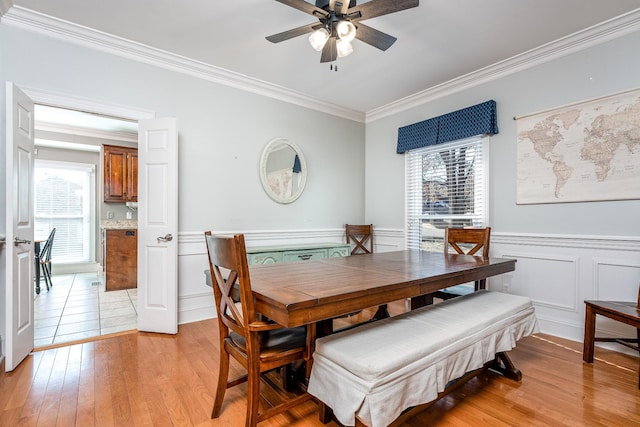 dining room featuring crown molding, a healthy amount of sunlight, and light hardwood / wood-style flooring