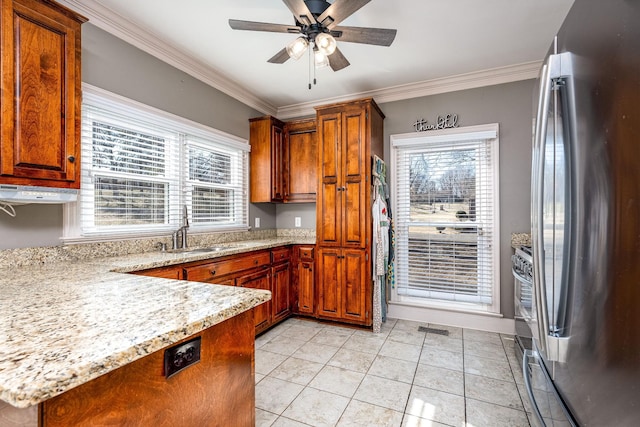 kitchen featuring sink, crown molding, stainless steel fridge, and light stone countertops