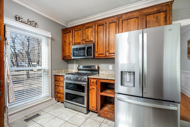 kitchen with light stone countertops, crown molding, appliances with stainless steel finishes, and light tile patterned floors